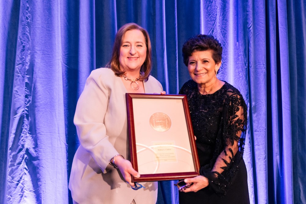 Laura Ricketts presents the Corporate Achievement Award to Debra Cafaro.